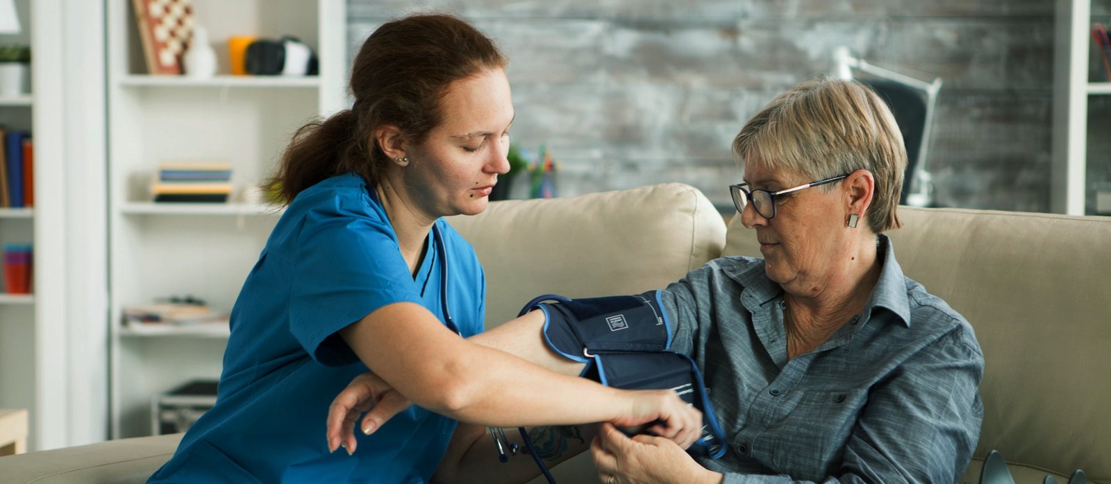 elder man sitting on a couch with caregiver