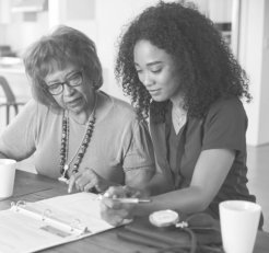 caregiver with elder woman filling up forms
