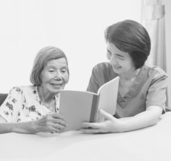caregiver and elder woman reading